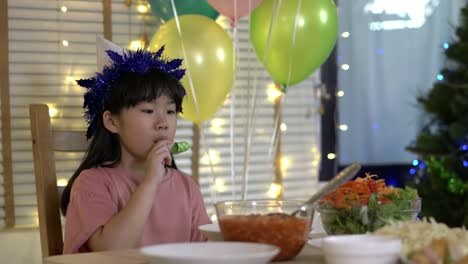 Asiatische-Kindermädchen-warten-Vater-und-Mutter-kommen-nach-Hause-Geburtstagsfeier-und-Abendessen-zusammen.-Unglückliche-Familienzeit-zu-Hause.-Konzept-von-einsam,-enttäuscht-und-traurig.