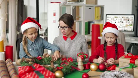 Fröhliche-Frau-und-kleine-Mädchen-machen-Weihnachtsvorstellungen-zusammen