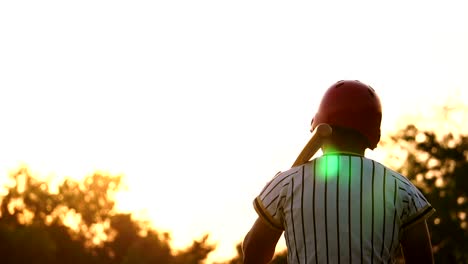 Baseballspieler-hält-einen-Baseballschläger-mit-dem-Licht-des-Sonnenuntergangs