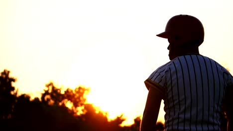 Baseball-Spieler-hält-einen-Baseball-mit-dem-Licht-des-Sonnenuntergangs