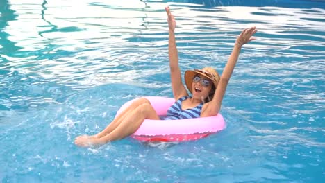 Girl-slow-motion-playing-and-swimming-on-ring-rubber-floating-on-swimming-pool