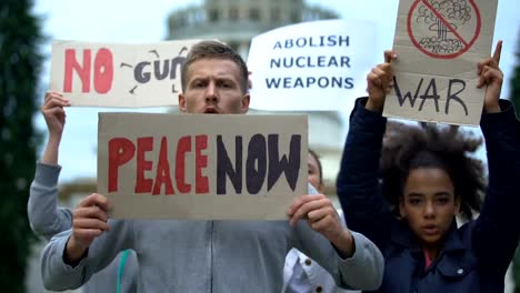 Activists-waving-banners-protesting-against-mass-shootings,-nuclear-weapon,-war