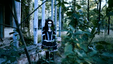 Halloween-make-up.-A-young-woman-standing-in-front-of-abandoned-wooden-house.-4K