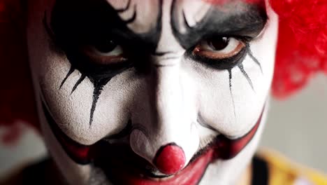 Scary-sad-clowm-opening-eyes-and-looking-at-camera-on-Halloween,-face-closeup