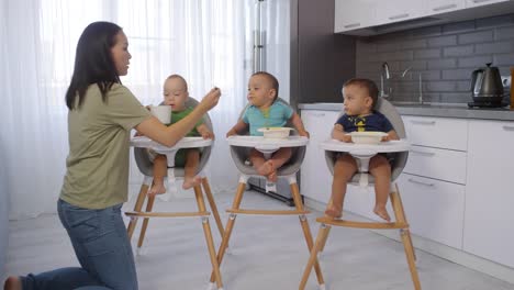 Asian-Mom-Feeding-Puree-to-Toddler-Triplets