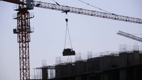 Tower-Crane-on-a-Construction-Site-Lifts-a-Load-at-High-rise-Building