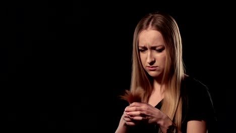 Beautiful-sad-woman-holding-split-ends-of-her-hair