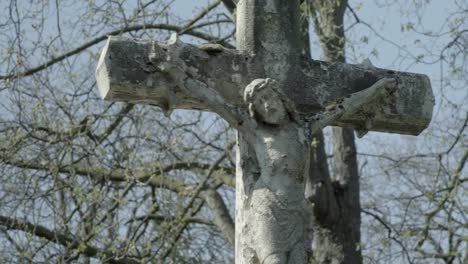 Alter-Grabstein-mit-Jesuskreuz-an-einem-sonnigen-Frühlingstag.-Schwenken-Sie-von-links-nach-rechts-zum-Kreuz.-4K-in-SLOG3.-Mittlerer-Schuss.