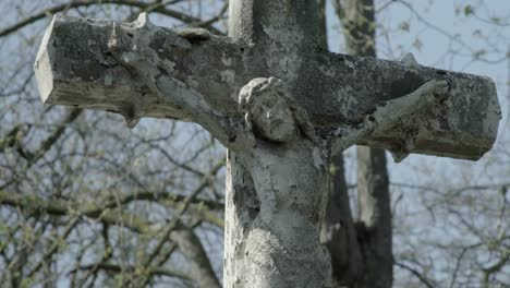 Vieja-lápida-con-jesús-cruz-en-un-día-soleado-de-primavera.-Desenfocarse-en-la-cruz.-4K-en-SLOG3.-Disparo-medio.