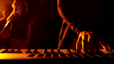 Mid-section-of-musician-playing-electronic-piano-in-studio