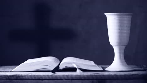 open-bible-with-chalice-and-cross,-shallow-depth-of-field,rack-focus