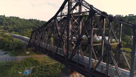 Rising-Aerial-Establishing-Shot-of-Coal-Train-on-Railroad-Bridge