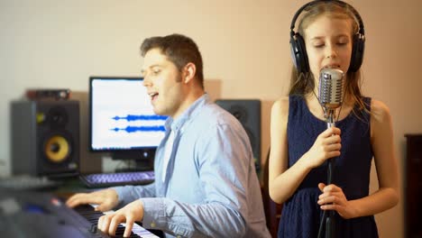 Hombre-con-niña-ensayando-la-canción-en-estudio-de-música.