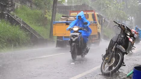 Traffic-along-a-typical-street-on-the-road-during-the-rain-in-island-Bali,-Indonesia