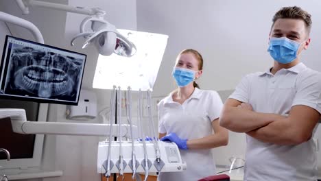 portrait-of-smiling-medical-staff-into-sterile-masks-and-white-special-clothes-at-work-in-clinic