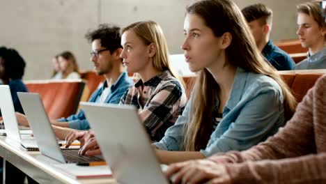 Large-Group-of-Multi-Ethnic-Students-Working-on-the-Laptops-while-Listening-to-a-Lecture-in-the-Modern-Classroom.-Bright-Young-People-Study-at-University.