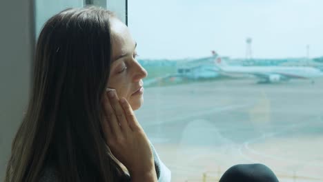 Joven-mujer-triste-está-llorando-en-el-aeropuerto-con-el-avión-en-el-fondo