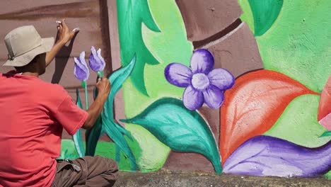 Pintor-mural-dibuja-jardín-en-la-pared-de-la-escuela