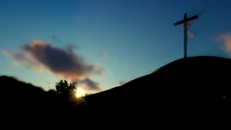 Christian-woman-praying-at-Jesus-cross,-sunset,-panning,-zoom-out
