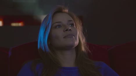 Woman-smiling-face-watching-movie-sit-in-cinema