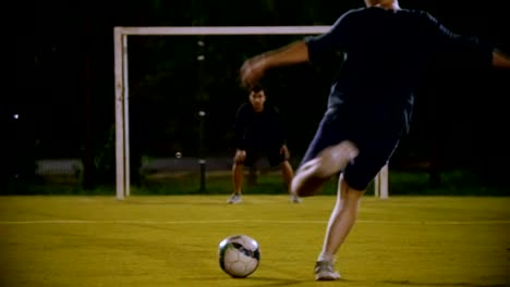 The-ball-lies-on-the-grass-in-the-foreground,-the-goalkeeper-is-at-the-gate,-the-other-player-kicks-the-ball,-but-does-not-hit-the-goal