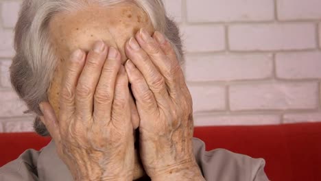 Woe.-An-elderly-woman-covers-face-with-hands