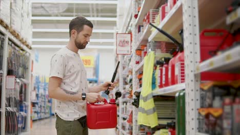 Man-is-learning-a-red-plastic-canister-for-automobile-in-a-shop