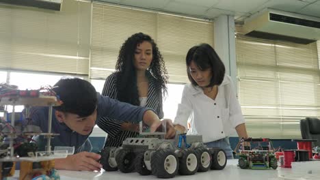 Equipo-de-ingeniero-electrónico-trabajando-juntos,-colaborando-en-un-proyecto-para-construir-el-robot.-Personas-con-el-concepto-de-tecnología-o-innovación.