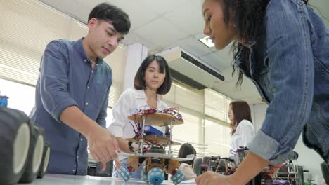 Team-of-electronics-engineer-working-together,-collaborating-on-a-project-to-build-robot.-People-with-technology-or-innovation-concept.