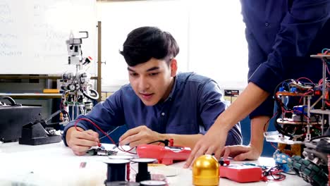 Männliche-Ingenieur-Ausbildung-zum-Arbeiten-mit-Robotik-Prototyp-in-Werkstatt.-Menschen-mit-Wissenschaft,-Technologie,-Bildungskonzept.