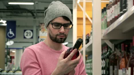 Man-in-a-supermarket-choosing-the-right-wine