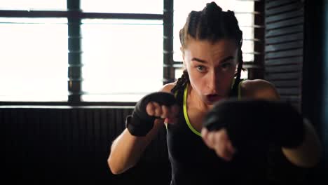 mujer-joven-hermosa-mueve-boxeo-entrenamiento-en-gimnasio-de-perforación