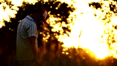 Männer-sind-den-Baseball-Spieler-mit-dem-Sonnenuntergang-schlagen.