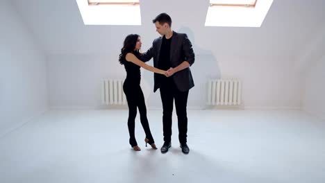 Young-couple-dancing-the-salsa-or-bachata-at-the-dance-hall.