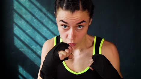 Closeup-Retrato-mujer-hermosa-joven-boxeo-entrenamiento-perforando-en-gimnasio-en-cámara-lenta