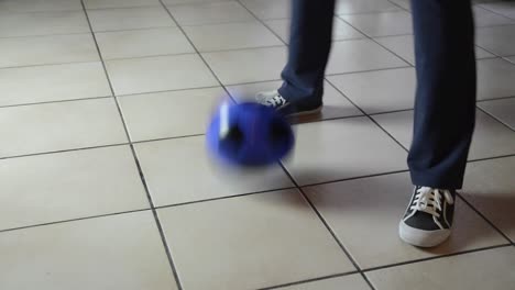 Detalle-de-pie-de-niño-jugando-con-balón-en-el-suelo-en-casa