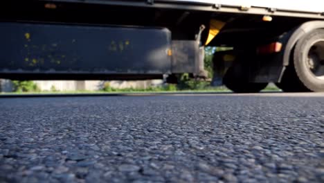 Blurred-shot-of-truck-driving-along-highway-in-country-road.-Lorry-rides-through-the-rural.-Slow-motion-Low-angle-view-Close-up