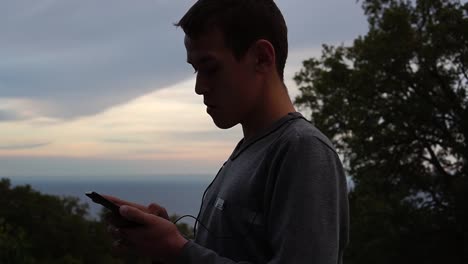 Silhouette-of-a-teenager-with-a-smartphone