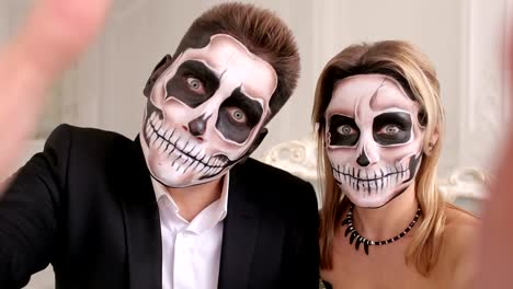 Creepy-couple-with-scary-Halloween-makeup-make-selfies-in-a-studio.