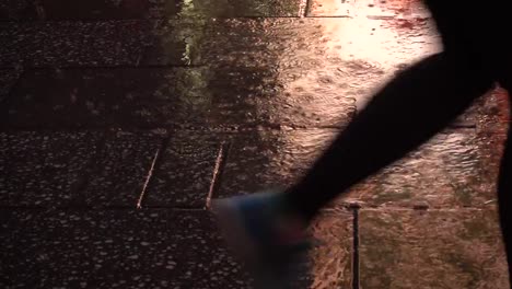 People-walking-at-night-on-a-sidewalk-during-a-rainy-day.