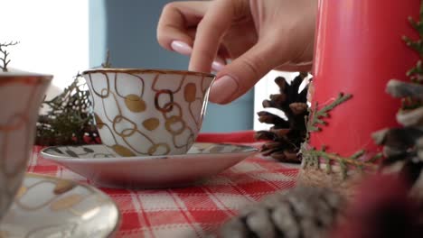 Girl-puts-a-cup-on-the-New-Year's-table