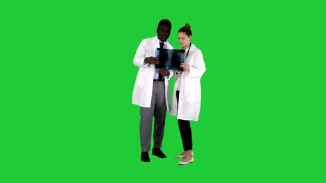 Young-female-doctor-and-afro-american-doctor-looking-at-the-x-ray-picture-of-lungs-on-a-Green-Screen,-Chroma-Key