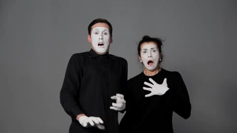 Scared-mime-artists-man-and-woman-on-grey-background.