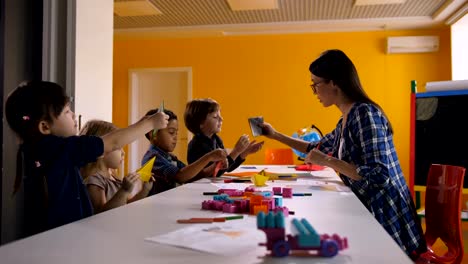 Multi-étnica-a-los-niños-crear-origami-en-clase-de-arte