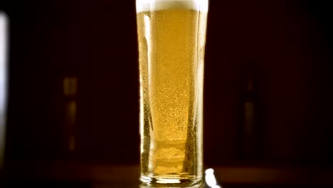 Close-up-slow-motion-Cold-Light-Beer-in-a-glass-with-water-drops-on-bar-background.-Craft-Beer-close-up