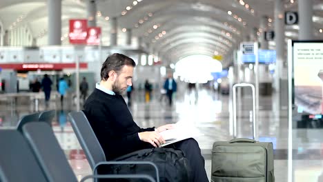 Passenger-reading-a-magazine-at-departure-lounge-at-the-airport