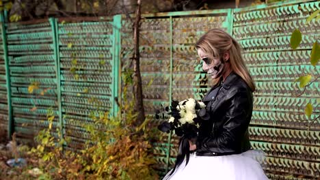 Creepy-novia-con-un-ramo-de-flores-negras-y-el-maquillaje-en-forma-de-un-cráneo