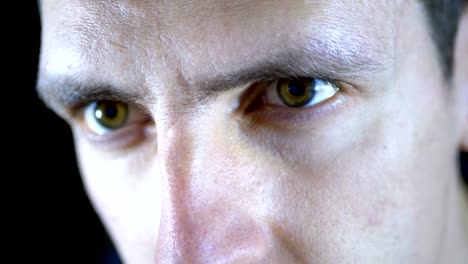 Close-up-of-the-eyes-and-face-of-a-young-man-working-at-a-computer-on-a-Black-Background