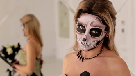 Girl-in-dress-with-a-bouquet-of-black-flowers-and-makeup-in-the-form-of-skeleton