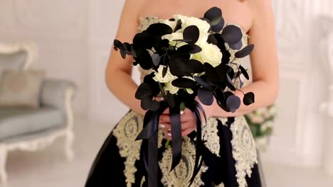 A-young-blonde-in-a-black-dress-with-a-bouquet-of-black-flowers.-Halloween.